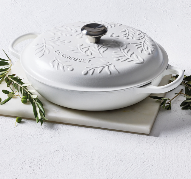 indigo blue cast iron braiser with olive branch design embossed on the lid