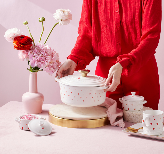 white dutch oven adorned with little red and pink hearts