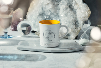 white mug with yellow interior and a fish design on side