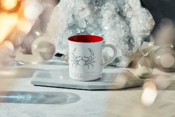 white mug with red interior and a crab design on side