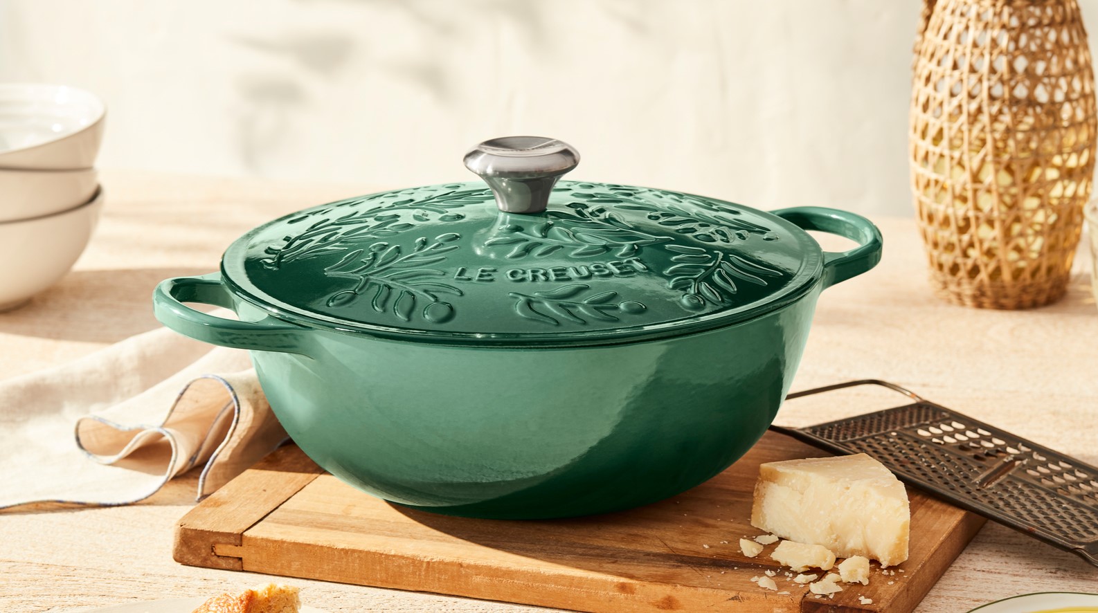 collection of cookware in various colors with an olive branch embossed pattern