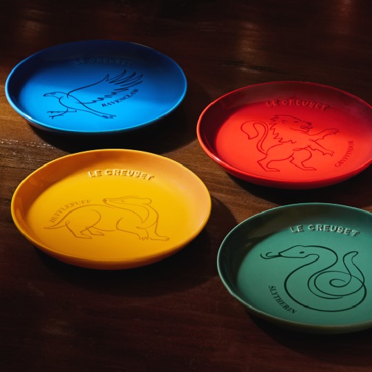 four round colored dessert plates featuring the house logo and color of each Hogwarts house