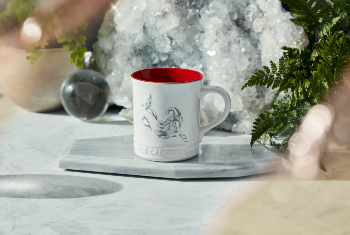 white mug with red interior and a goat design on side