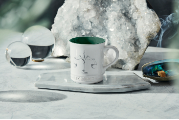 white mug with green interior and a scales design on side